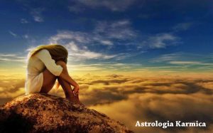 Conosci te stesso e migliora con l'Astrologia Karmica. Nell'immagine una giovane donna è su un monte al di sopra delle nuvole.